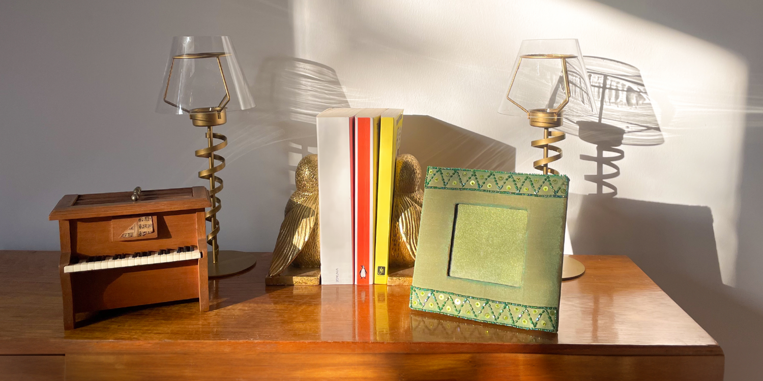 wooden side table with second hand home decor, candles, books, bookends, frames
