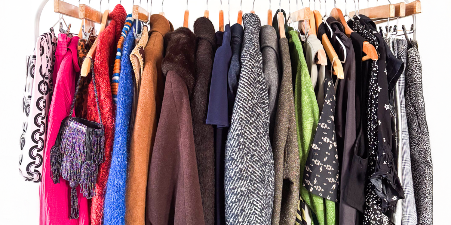 rail of colourful second hand womens clothes