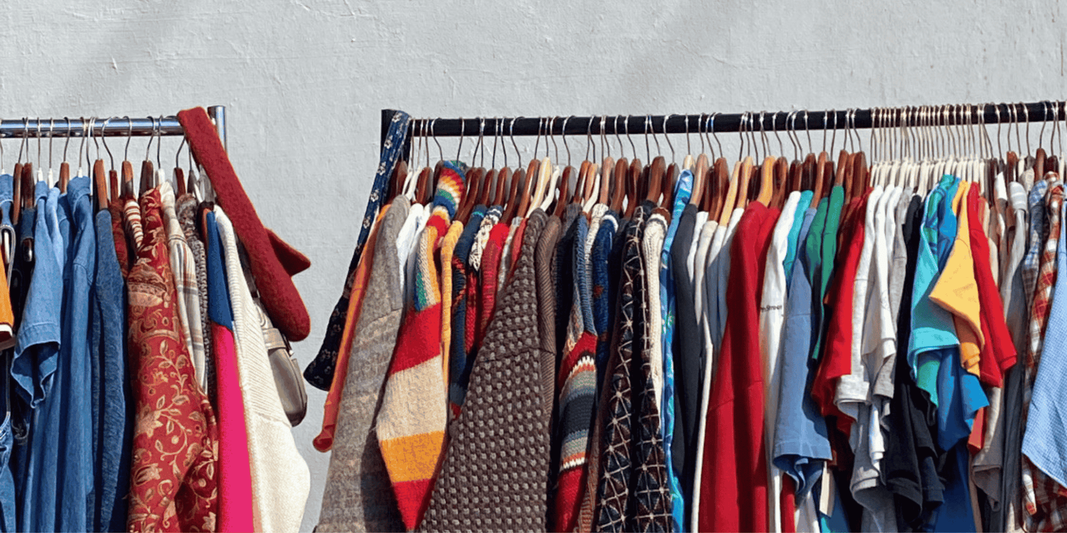 rail of sustainable fashion womens clothes outside on a rail in the sun