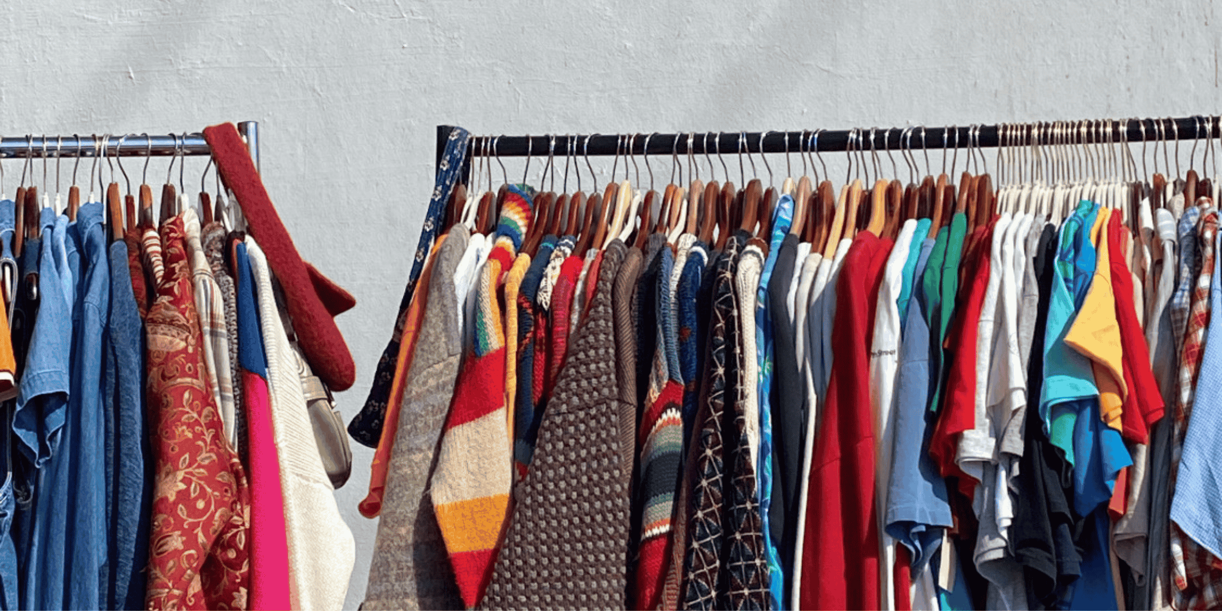 rail of sustainable fashion womens clothes outside on a rail in the sun