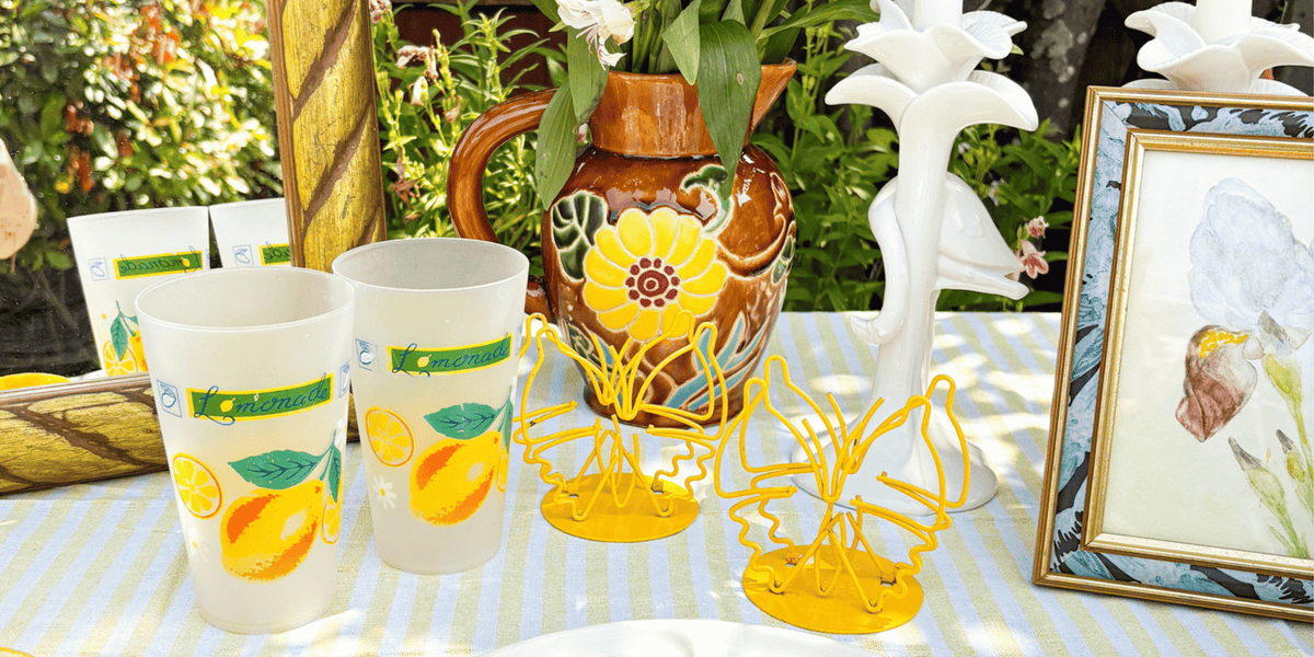 outdoor table decor using only second hand home decor including vintage artwork, jugs and candlestick holders