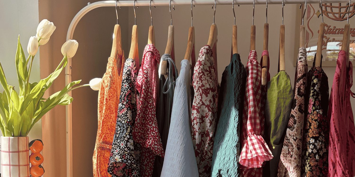 rail of womens clothes, specifically second hand womens summer dresses on a rail in the sun