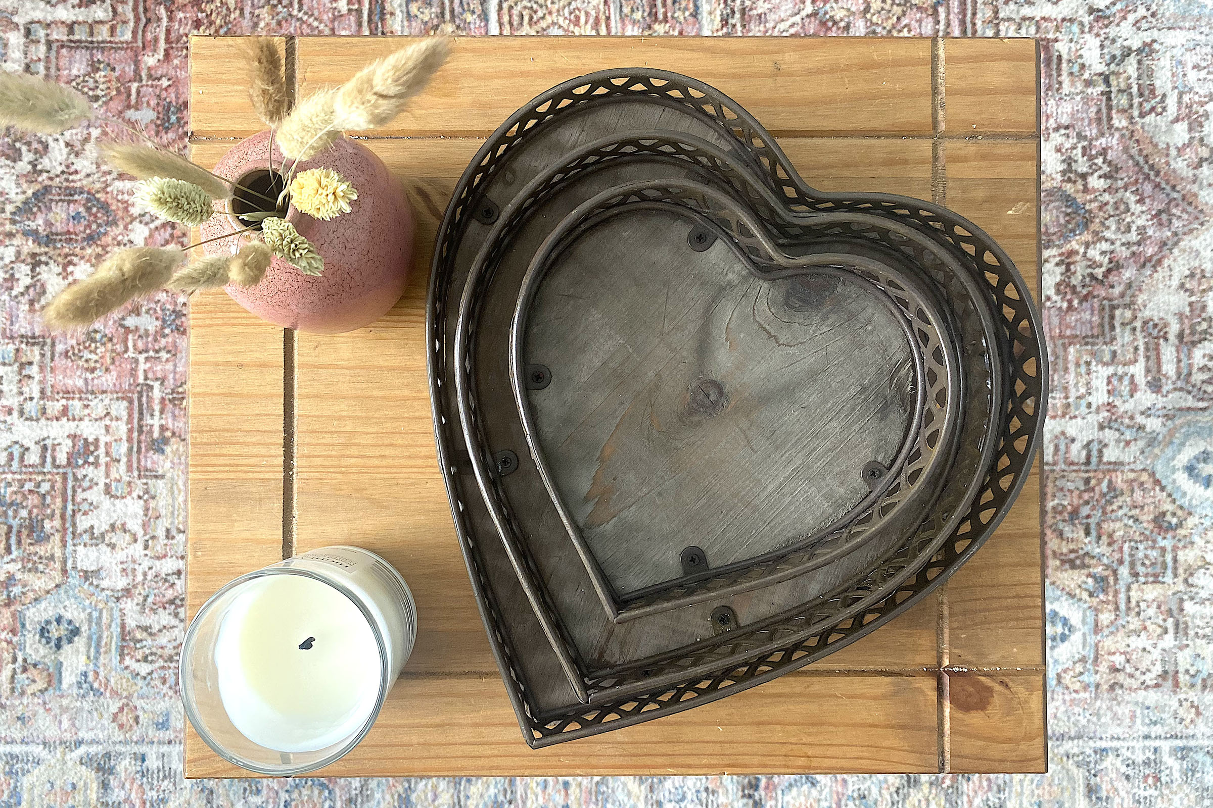 green vase with white flowers on a brown shelf next to an elephant ornament