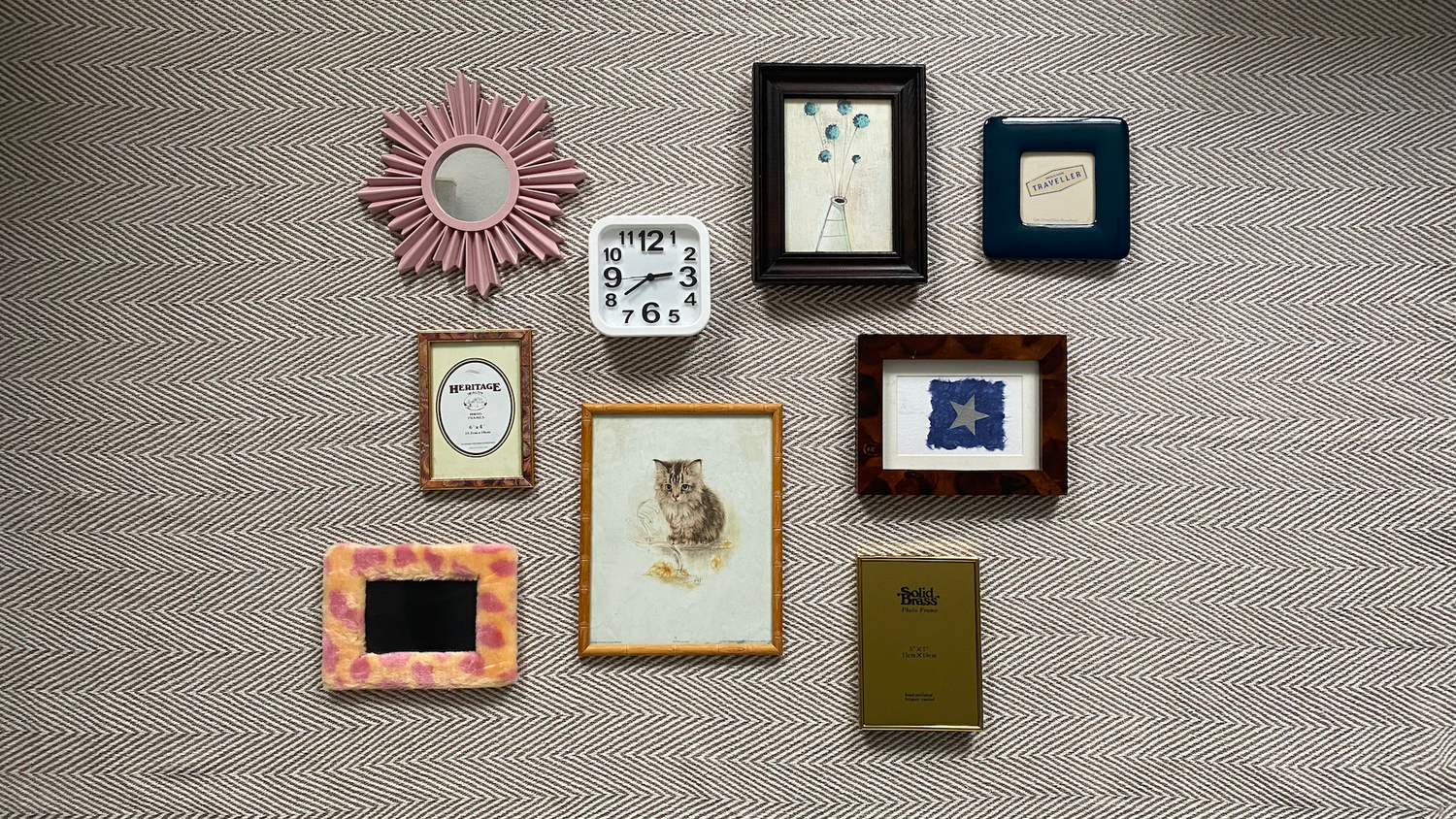 Small picture frames and a clock laid flat on the floor